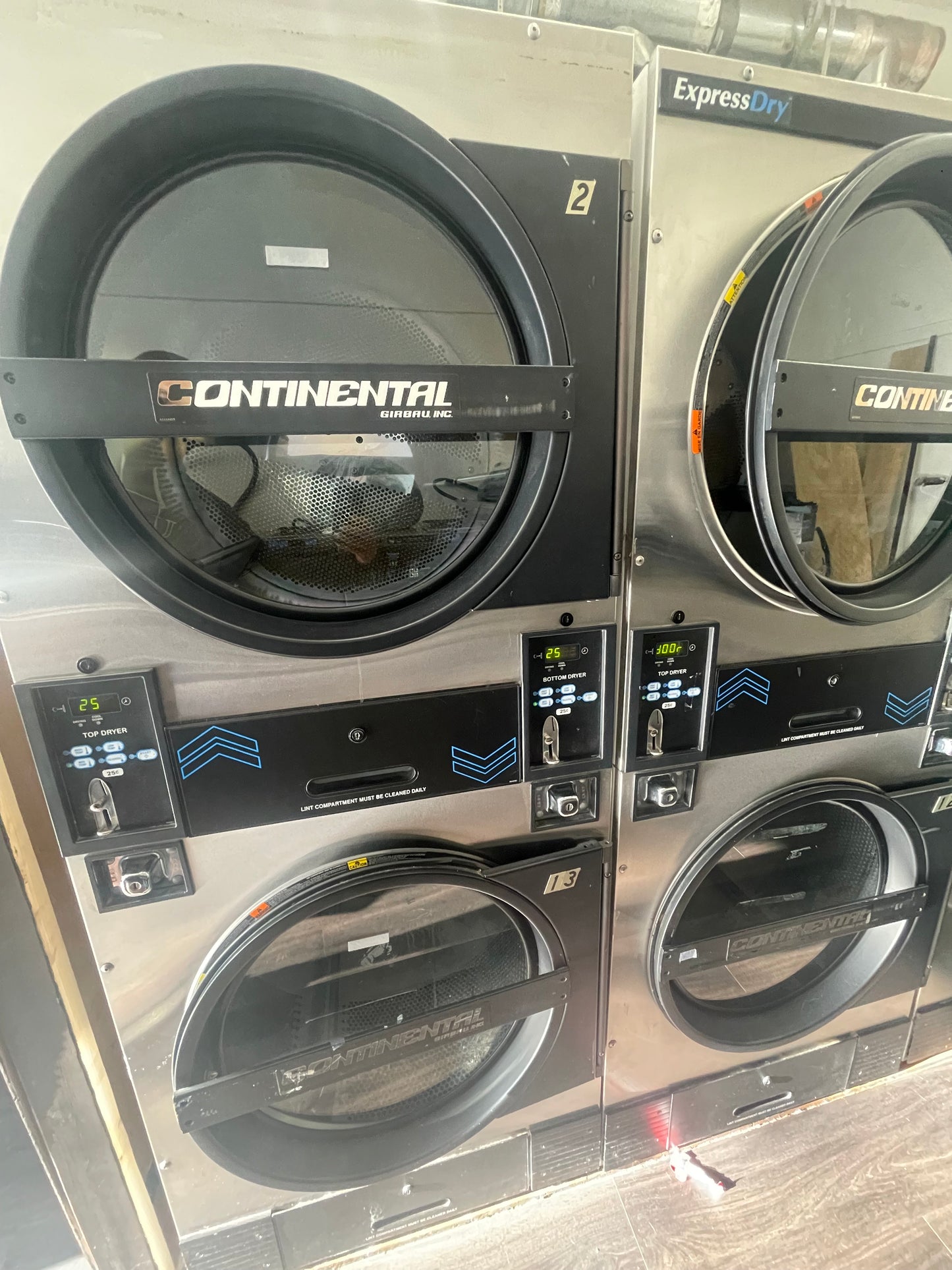 A set of Continental stack dryers with two pockets per dryer, model KTT30NBCB2H2N01, in a commercial laundry setting.